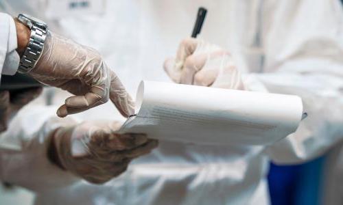 Two scientists looking over a clipboard. 